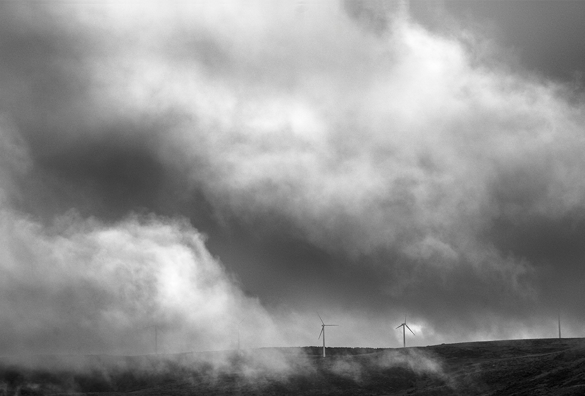 Molinos de viento entre nubes del paisaje en la Sierra de Ojos de Albos, Avila.