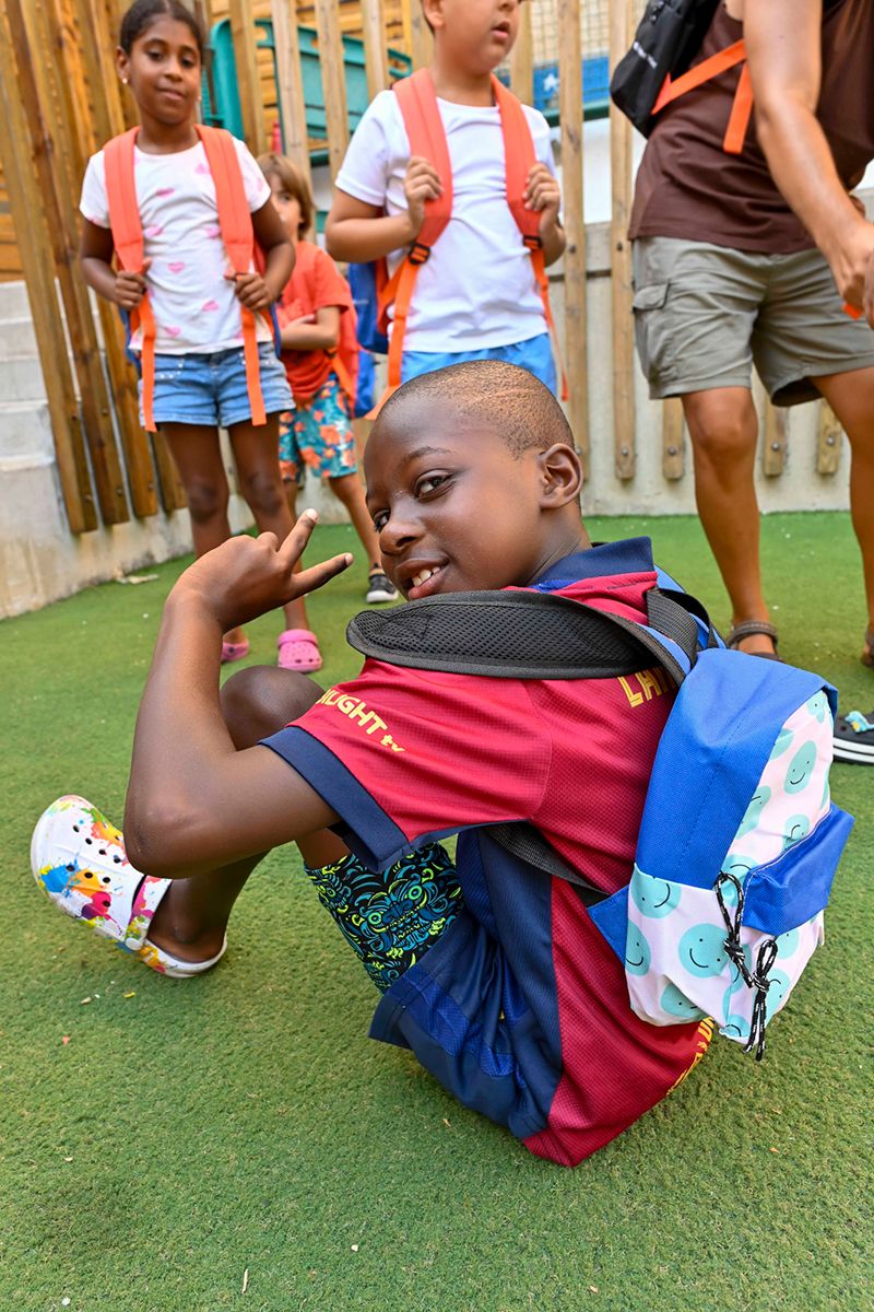 Un niño sonríe a cámara con su mochila nueva. © Fundación ”la Caixa”